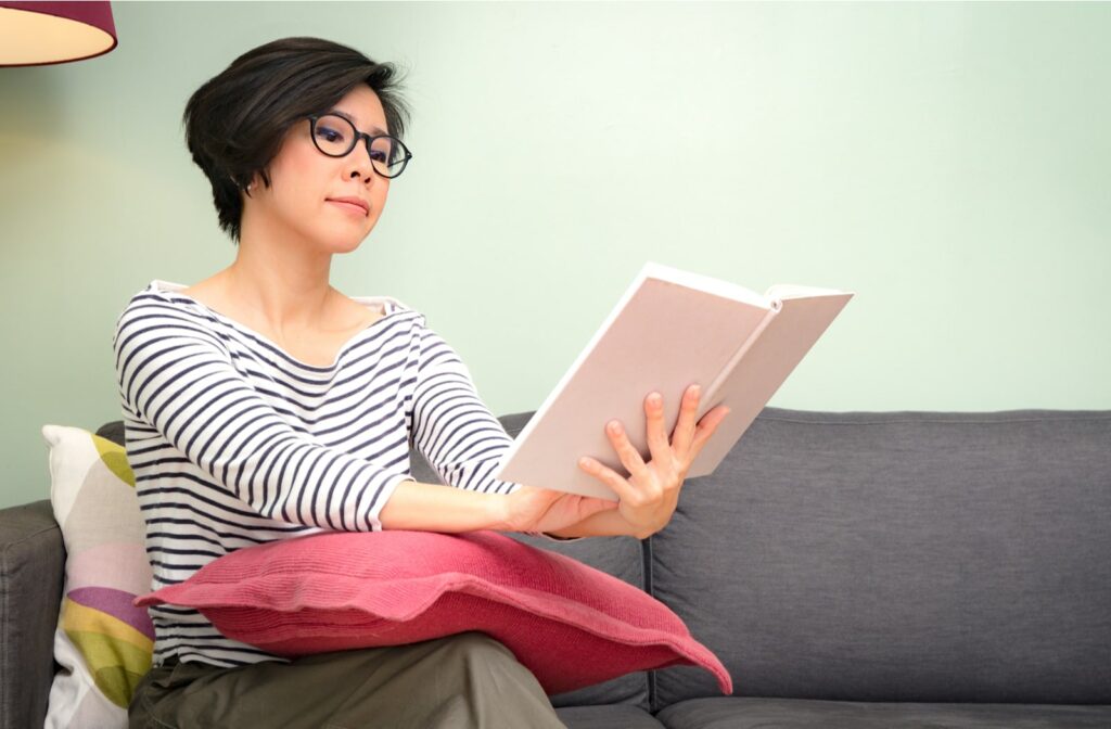 A woman using progressive lens glasses to read a book