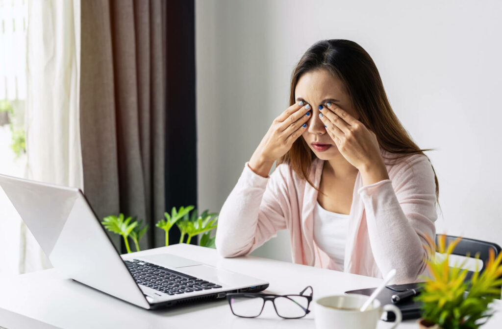 An office woman is massaging her eyes to relax from long time working on her computer.