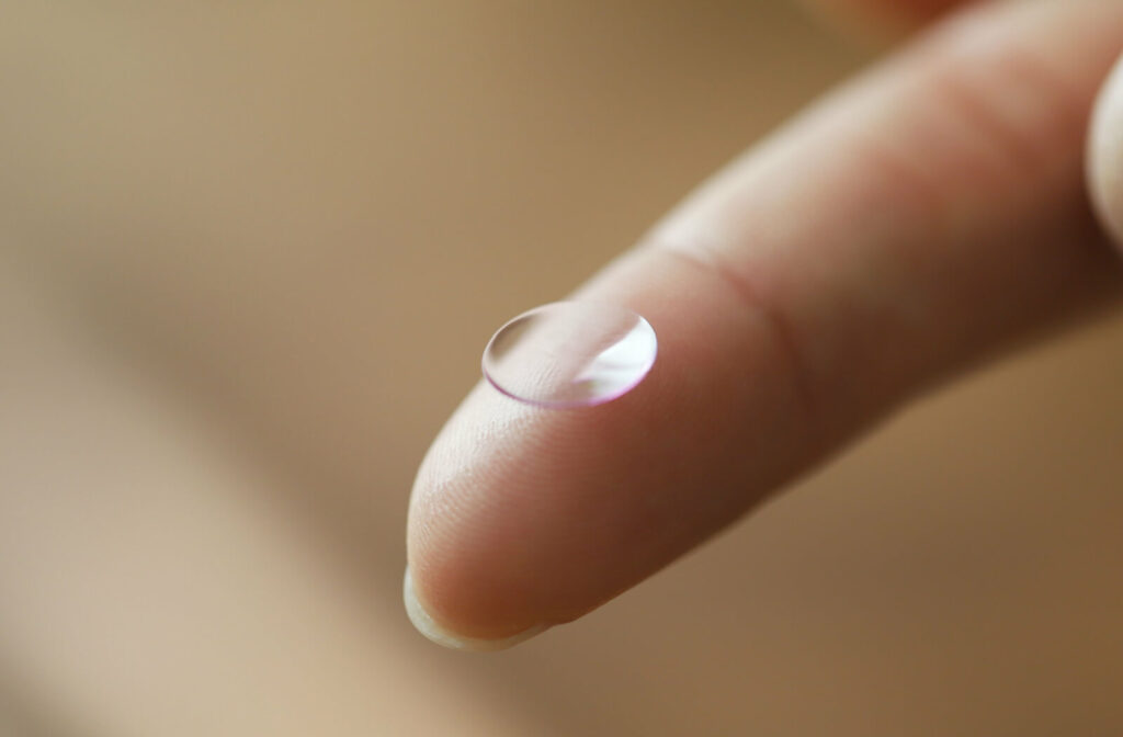 A close-up of a rigid gas-permeable lens at the tip of a finger. RGP lenses allow oxygen pass through the lens to keep your eyes healthy.