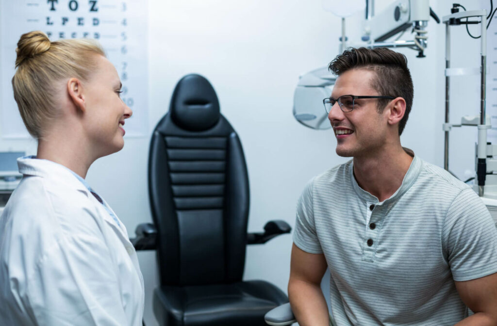 An optometrist talking to his male patient in an optical clinic.
