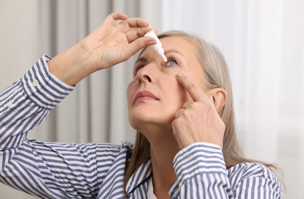 A person applying preservative-free lubricating eye drops to relieve dry eyes