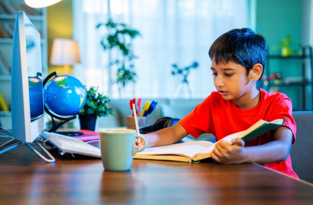 A young kid studying at a desk.